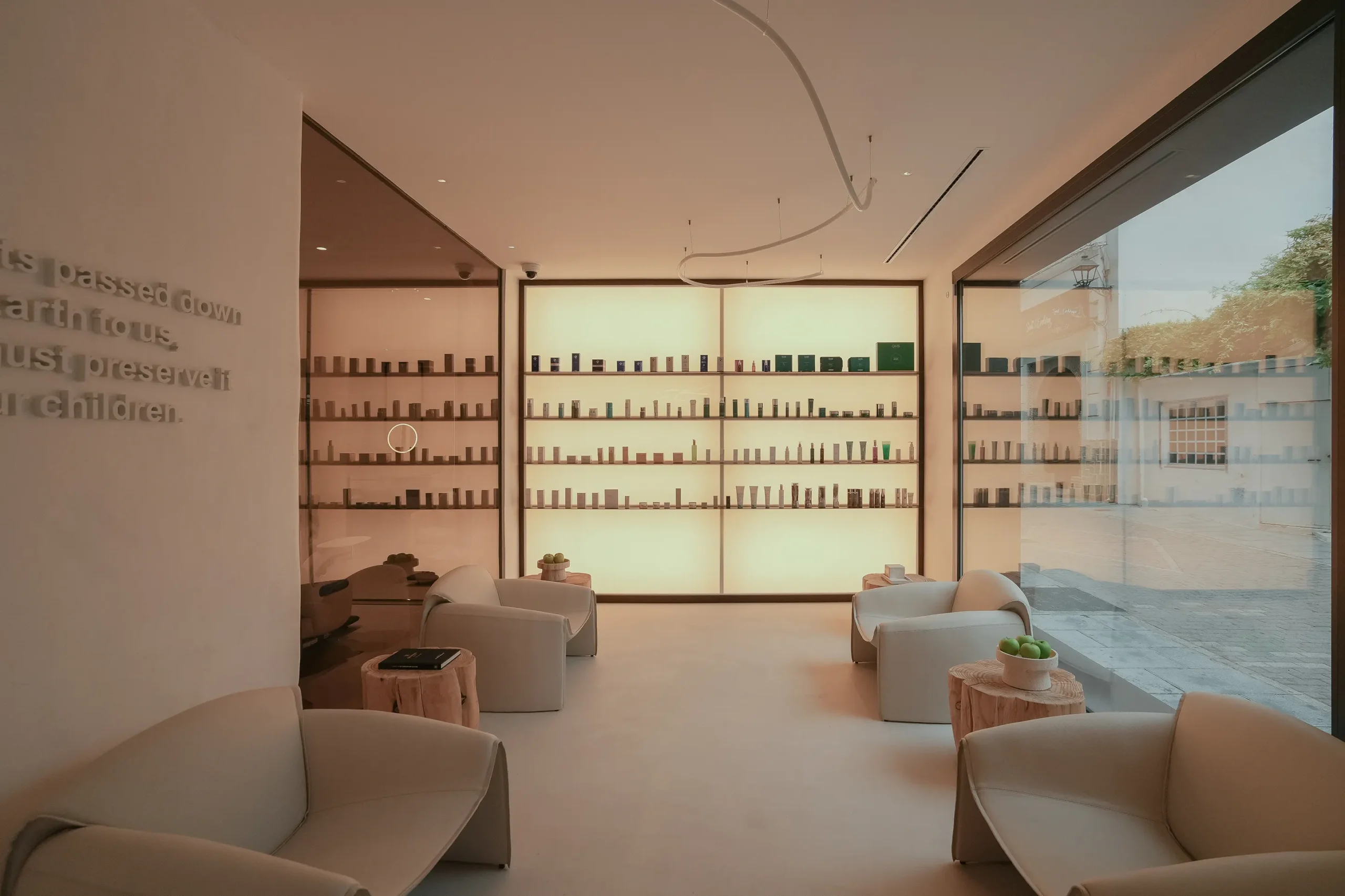 Milfey Beauty reception lounge with armchairs and skincare wall in Marbella
